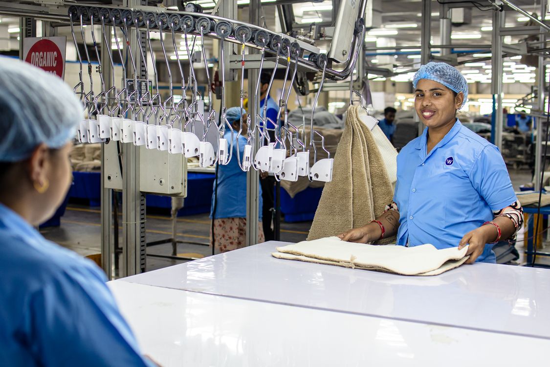 Equipo de trabajadores textiles uniformados colaborando en una fábrica